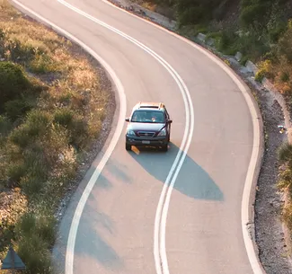 Car driving along a winding country road